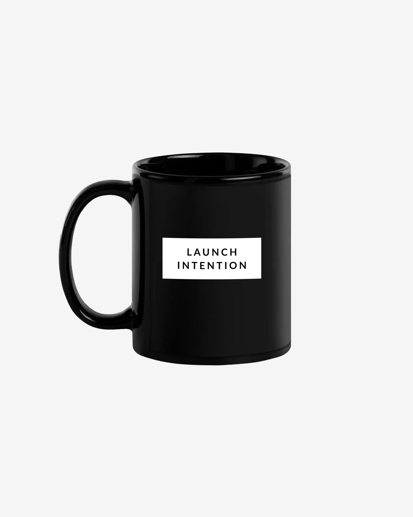 Left side of black Launch Intention staple coffee mug with paper plane branding