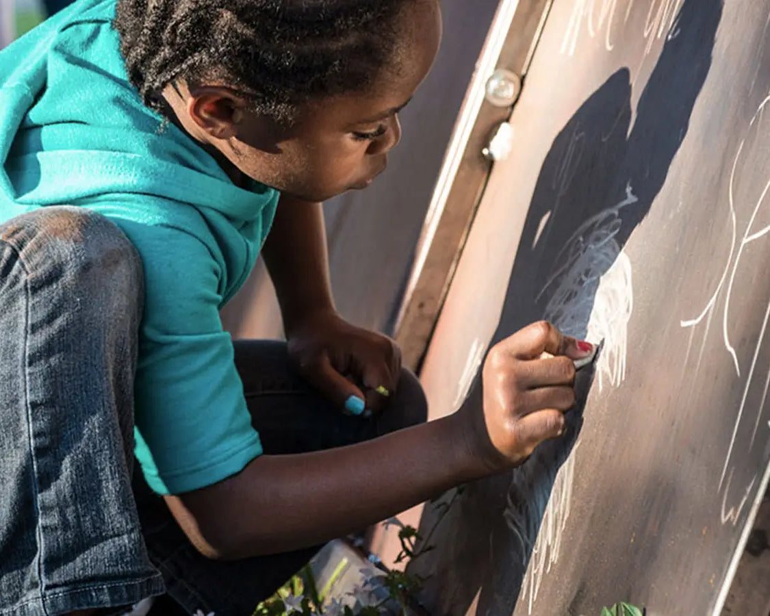 Child drawing on a Launch Intention 25ft Paper Airplane Sculpture at the Canvas Outdoor Museum in Palm Beach Florida.