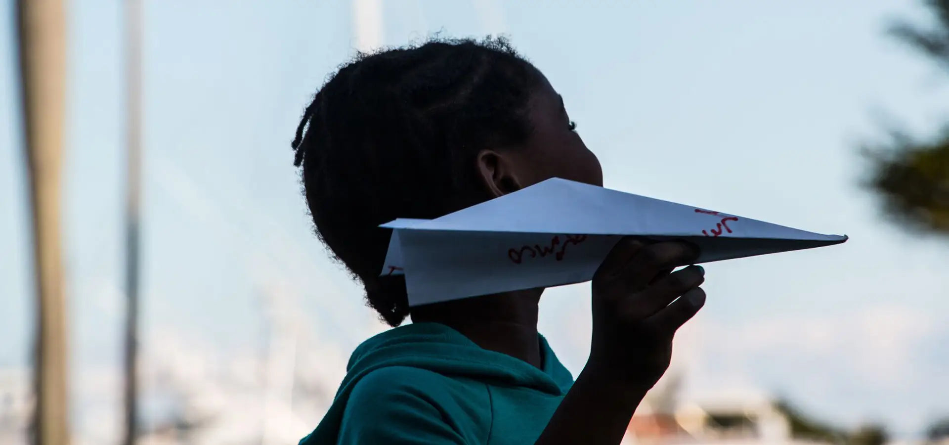 A young student getting ready to launch an intention paper plane at a Launch Intention activation in Palm Beach, Florida.