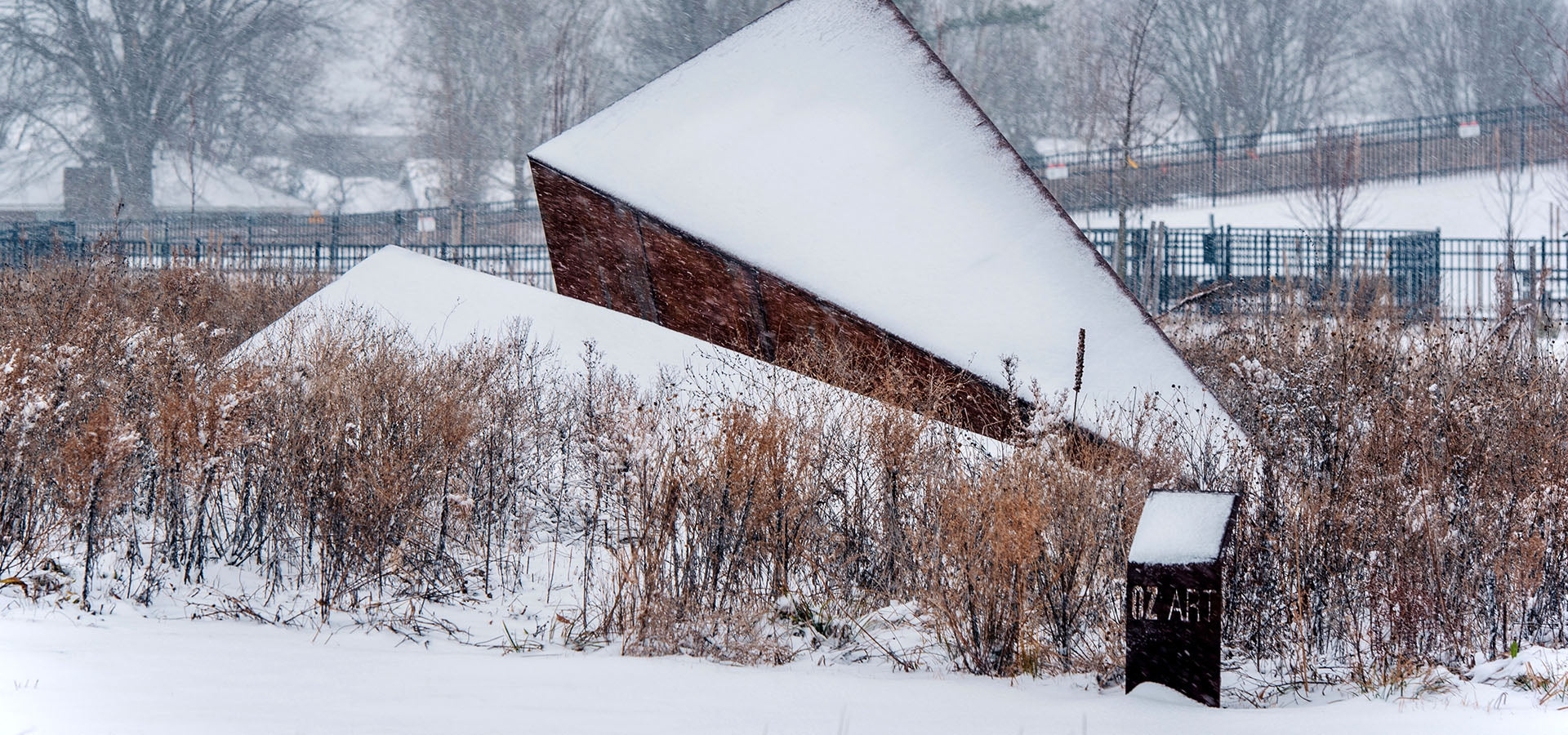  Snow-covered Launch Intention steel paper airplane sculpture by Griffin Loop rising from winter grasses at Osage Park, immersive public artwork inviting quiet moments of reflection 
