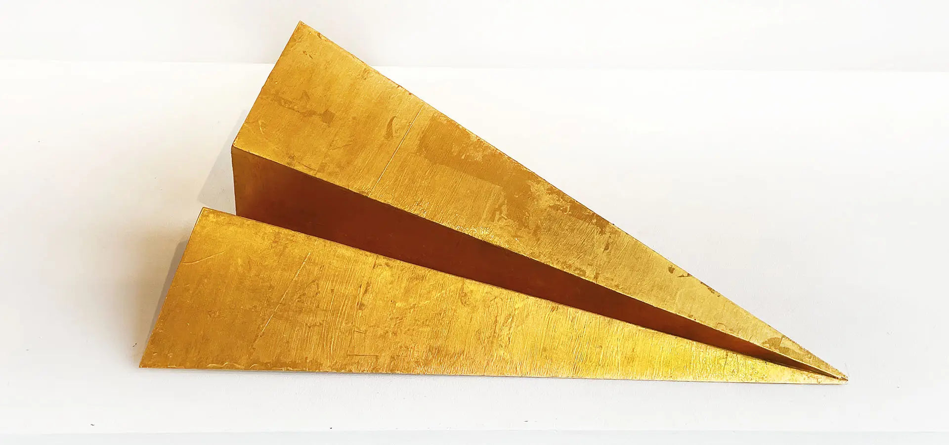 Golden Intention gold leaf paper airplane sculpture displayed in Aspen Sky Gallery