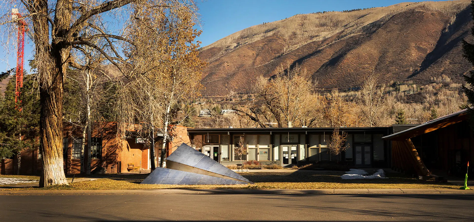 Launch Intention metal paper airplane sculpture sits in front of the Red Brick School in Aspen, Colorado for Aspen Art Week.
