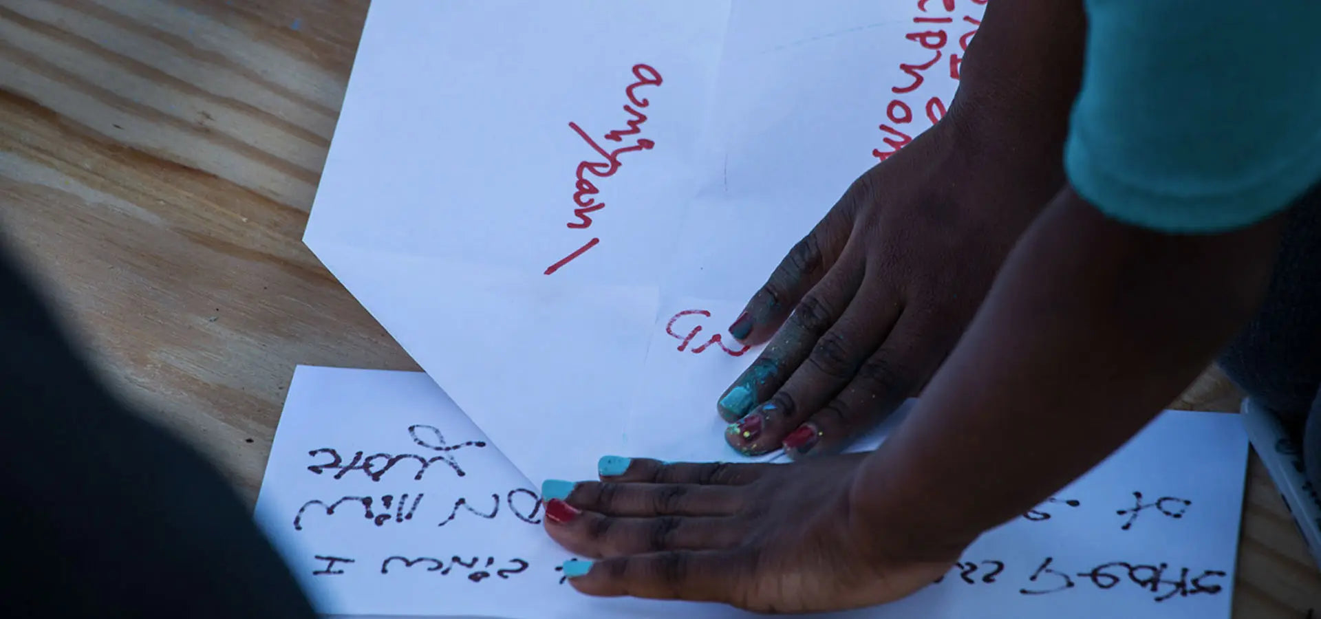 Child folding Launch Intention Paper Airplanes for the activation at the Canvas Outdoor Museum in Palm Beach Florida.