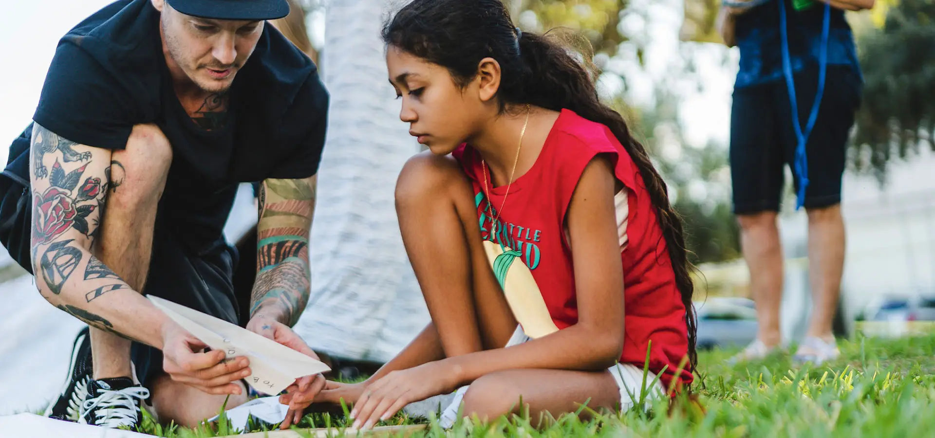 Launch Intention founder & artist Griffin Loop helps student fold a paper airplane during an activation in Florida.