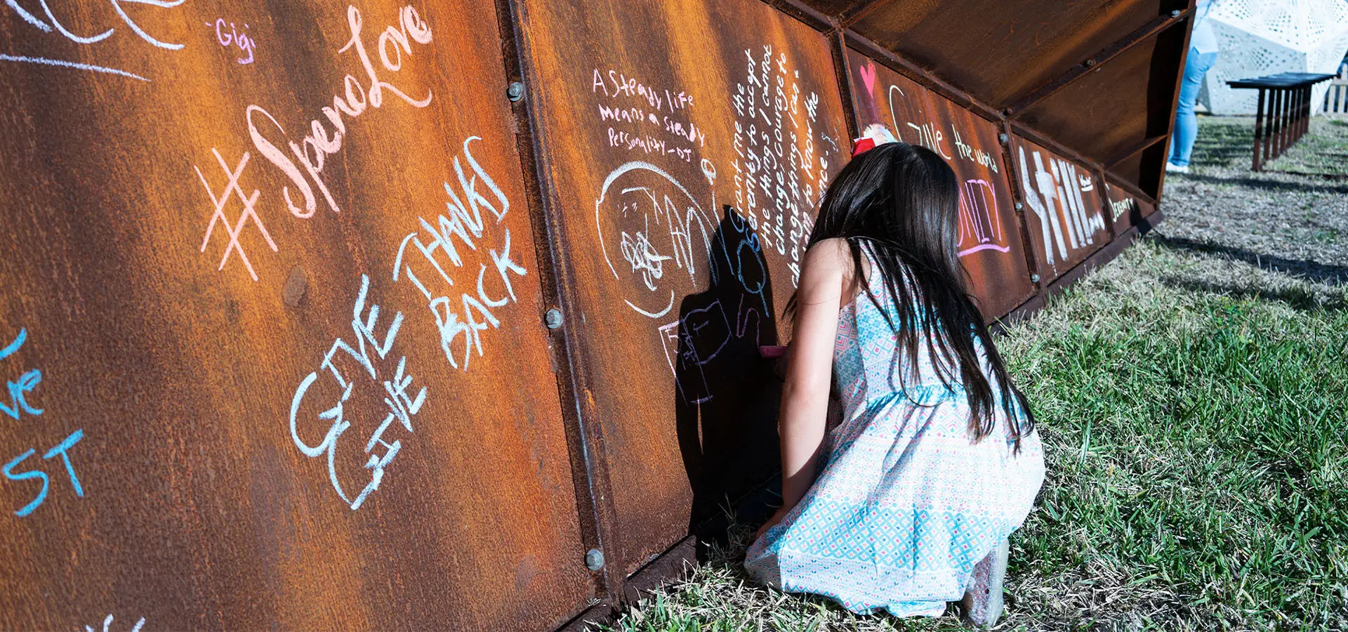 Launch Intention's large 25 foot metal paper airplane sculpture at the Canvas Oudoor Museum festival in Palm beach with a girl writing her intentions on the side.