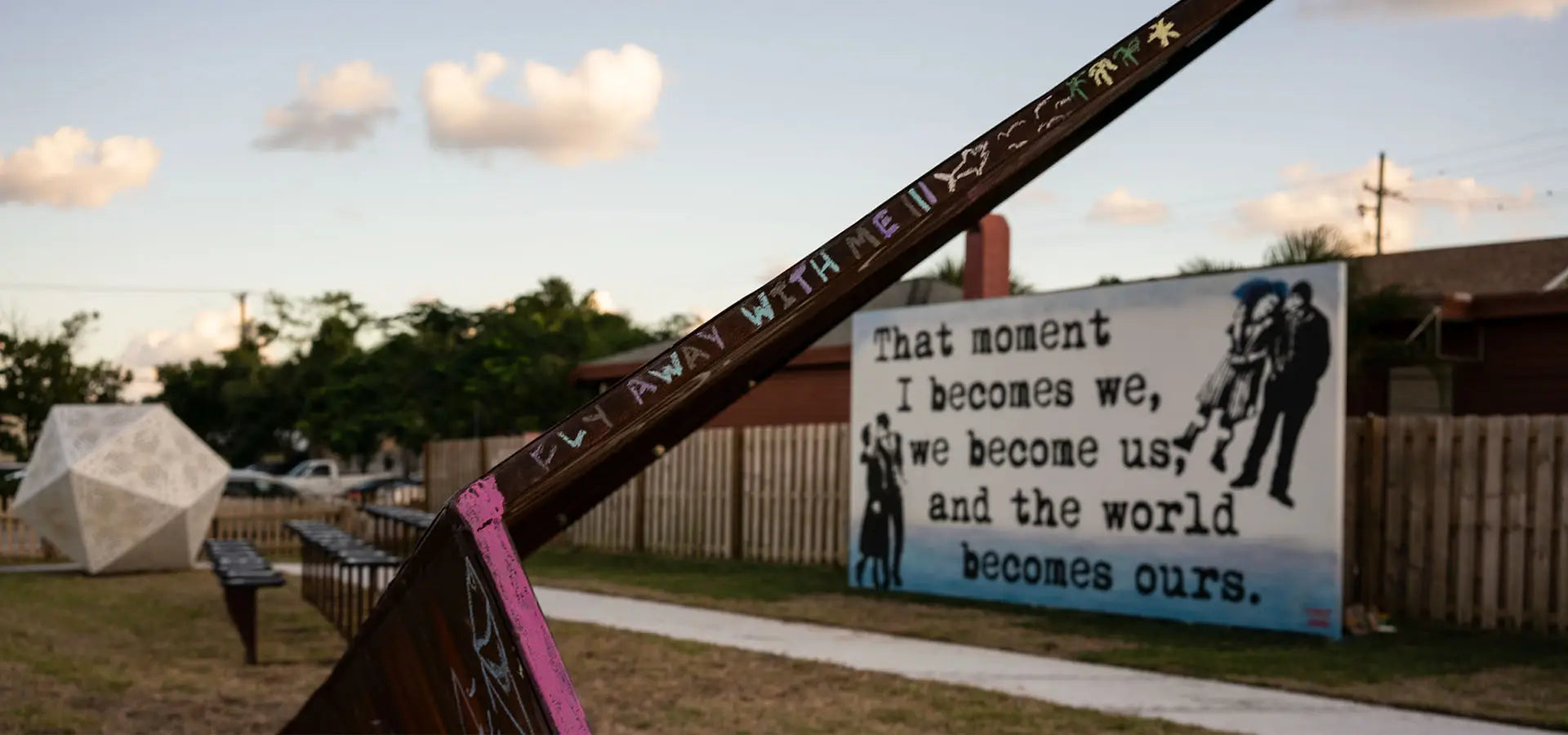 A Launch Intention Metal Paper Plane sculpture at the Canvas Outdoor Museum in Florida with "fly away with me" inscribed on the wing.